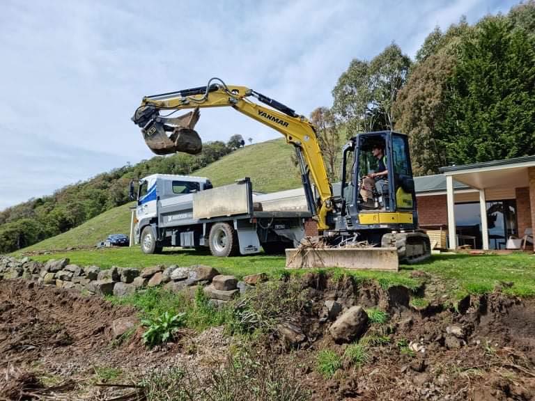 Excavator performing earthworks for driveway construction
